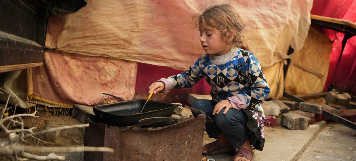 Niña cocinandola poca comida que tiene en el refugio de la escuela Al-Qastal, en Gaza. (Foto de archivo)