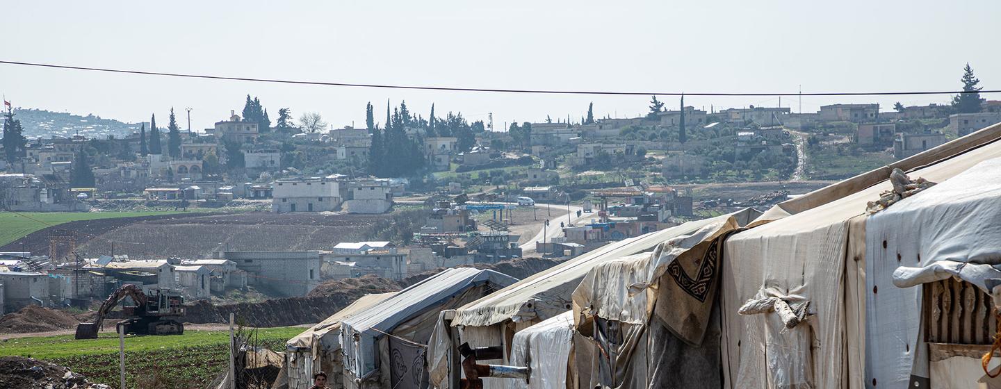 Des personnes se promènent parmi leurs abris et vaquent à leurs occupations quotidiennes dans le camp d'Al-Muhammadiyah pour personnes déplacées internes près de Jendires, Afrin, dans la campagne nord-ouest d'Alep, en Syrie, en février 2025.