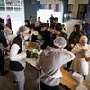 Voluntarios con redes para el cabello y máscaras sirven comidas calientes desde grandes tazones a familias desplazadas en un centro comunitario en el Líbano, como parte de un esfuerzo de ayuda del Programa Mundial de Alimentos (PMA).