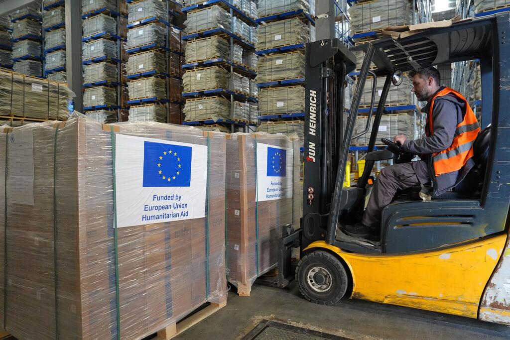 Mfanyakazi anaendesha forklift katika ghala, akisafirisha pallets za misaada ya chakula iliyoandikwa 'Imefadhiliwa na Msaada wa Kibinadamu wa Jumuiya ya Ulaya'. Hii ni sehemu ya hisa ya tani 1,000 inayowasili kwenye ghala la WFP huko Beirut, Lebanon.
