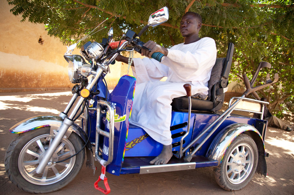 सूडानी एसोसिएशन फॉर डिसेबल्ड पीपल के सदस्य, शेज एल्डीन, सूडान के उत्तरी दारफ़ूर में संगठन द्वारा प्रदान की गई एक विशेष मोटरसाइकिल की सवारी करते हुए. (फ़ाइल)