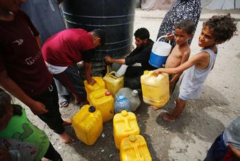 Des enfants recueillent de l'eau dans la bande de Gaza.