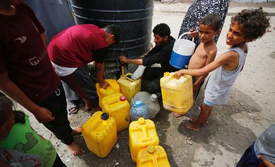 Unos niños recogen agua en la Franja de Gaza.