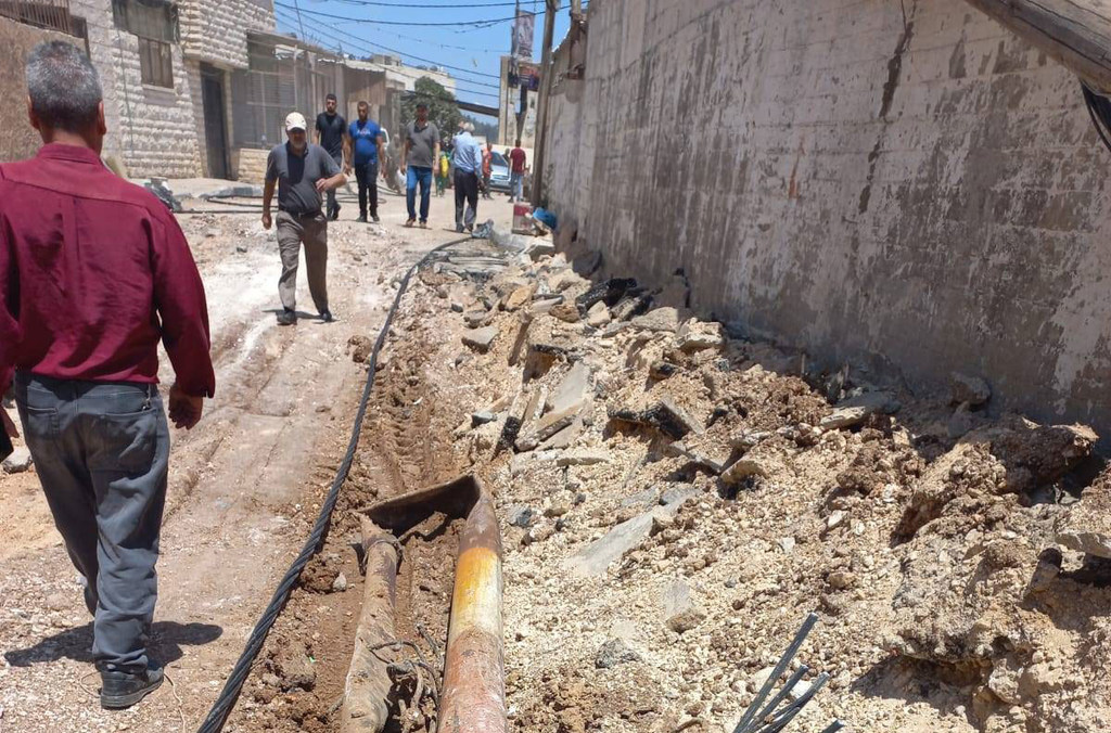 Des gens passent devant des infrastructures d'égouts et d'approvisionnement en eau endommagés dans la ville de Jénine, en Cisjordanie, à la suite d'une opération militaire israélienne de deux jours.