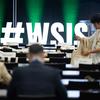 会议代表们在背景中可以看到巨大的#WSIS标志。