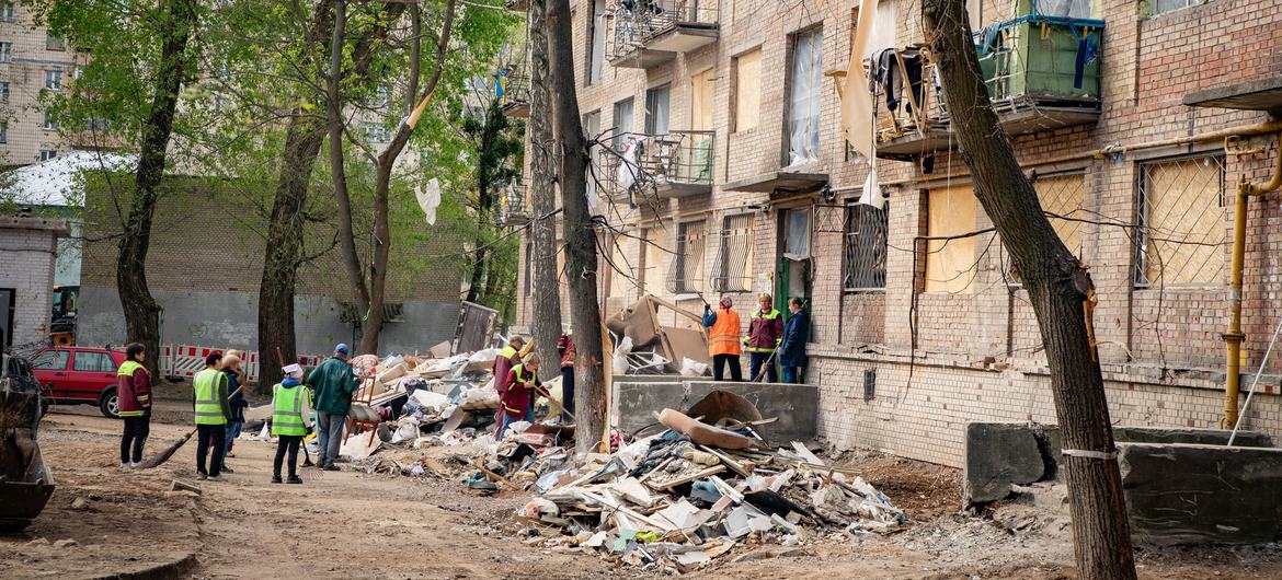 People gather around a damaged building in Kyiv, Ukraine.
