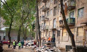 People gather around a damaged building in Kyiv, Ukraine.