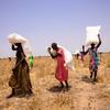 Des habitants récupèrent des sacs de céréales après un largage aérien du Programme alimentaire mondial (PAM) dans l'État de Jonglei, au Soudan du Sud.