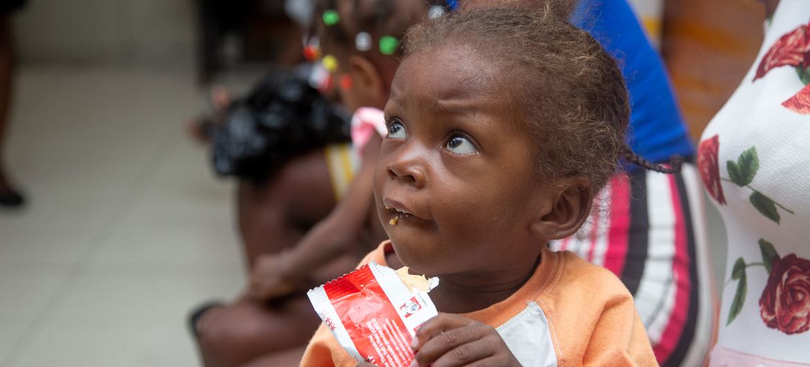 राजधानी पोर्त-ओ-प्रिन्स में एक स्वास्थ्य व पोषण केन्द्र पर एक बच्ची को पहले से तैयार पोषक भोजन दिया जा रहा है.
