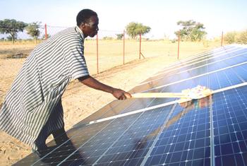 Житель Нигера чистит солнечные панели. 