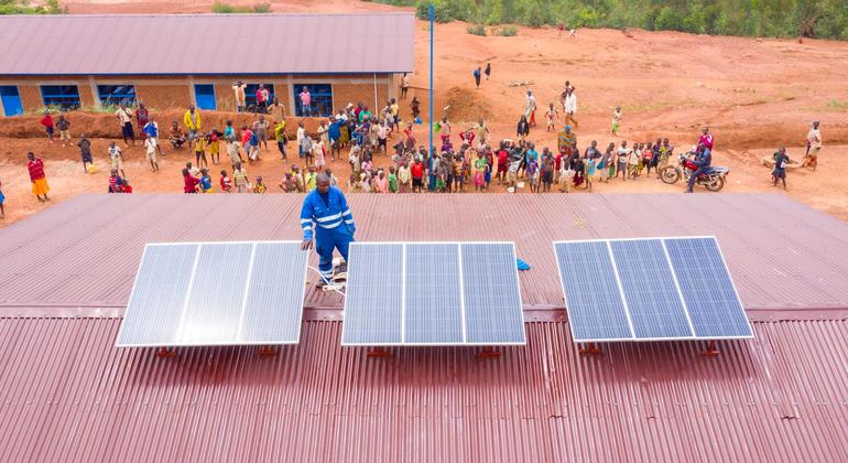 Un technicien installe des panneaux solaires sur un centre de santé au Burundi.