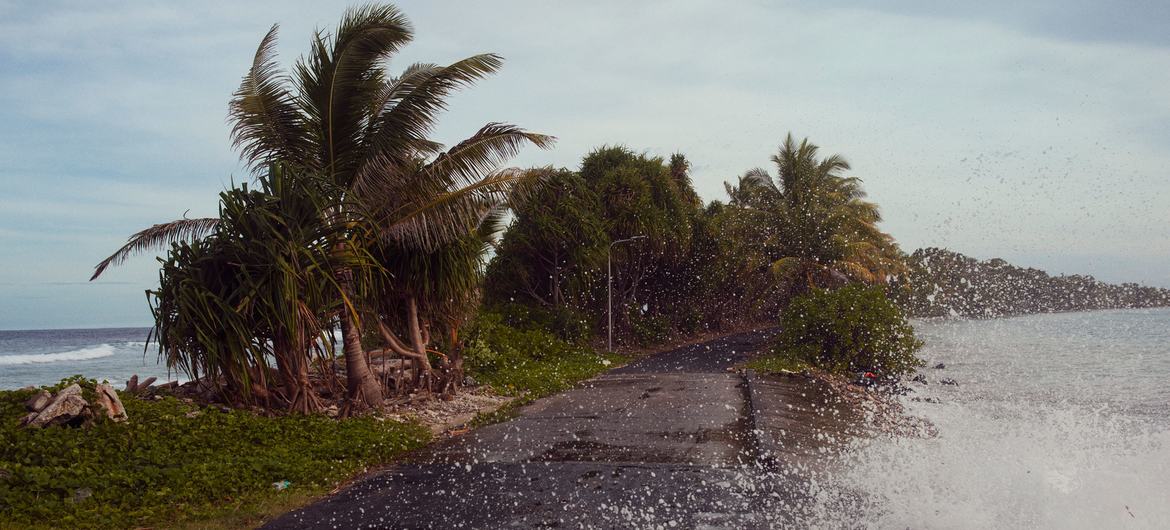 Waves crash against a road by Tuvalu's shoreline.