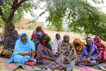 Un groupe de femmes de l'association NIA IDJE TEREY à Tombouctou, au Mali, sont assises ensemble sur une natte sous un arbre.