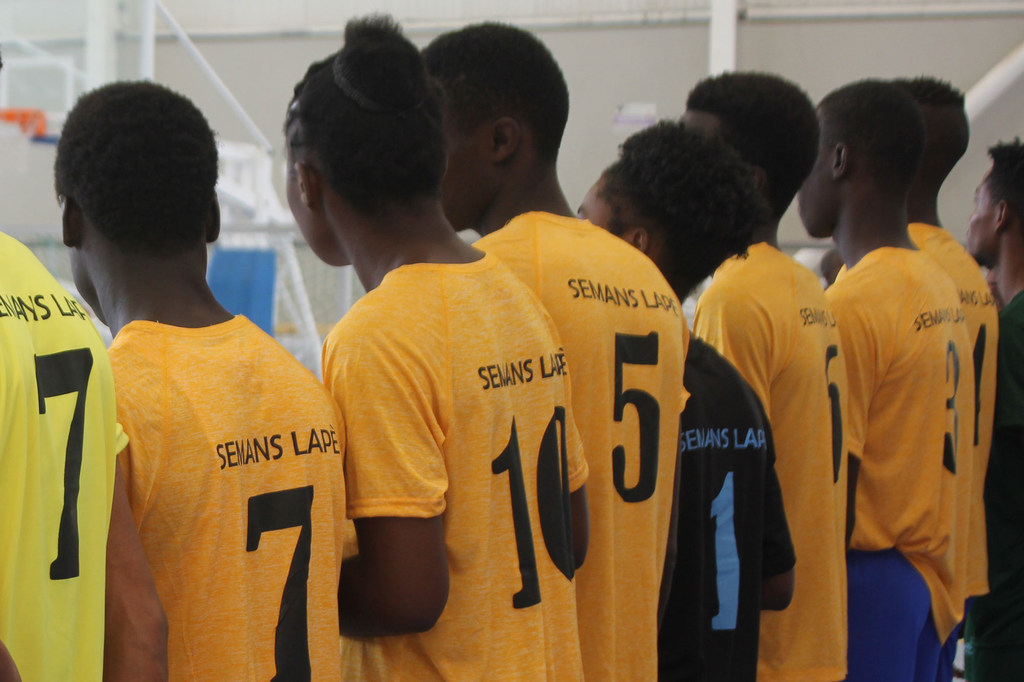 Mujeres y hombres jóvenes haitianos participan en un evento deportivo juvenil en Port-au-Prince
