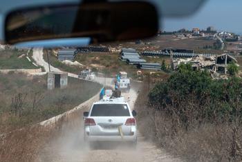 قافلة لوجستية تابعة لقوات UNIFIL ، تضم سيارة تويوتا لاند كروزر بيضاء اللون ومركبة مدرعة، تسير على طريق ترابي في جنوب لبنان.