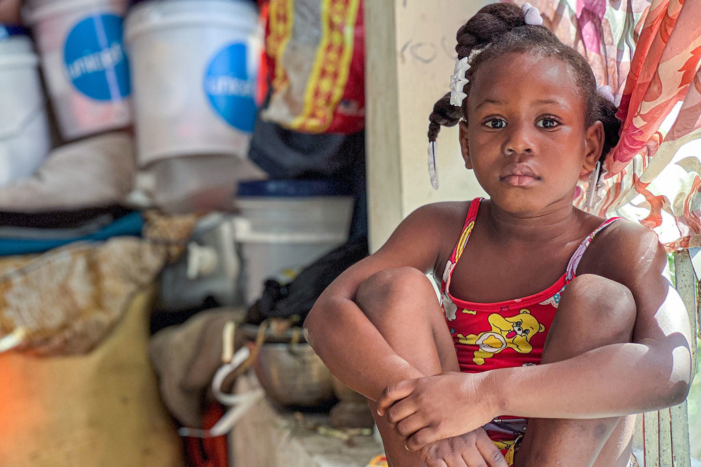 Una niña se sienta en un campamento provisional habilitado para personas que han huido de sus hogares debido a la violencia.