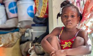 Una niña se sienta en un campamento provisional habilitado para personas que han huido de sus hogares debido a la violencia.
