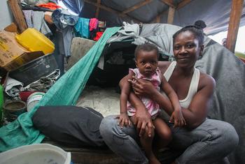 Une mère tient sa fille dans ses bras dans un abri de fortune, au sein d'une école, après avoir fui la violence des gangs armés à Port-au-Prince, en Haïti. Une mère tient sa fille dans ses bras dans un abri de fortune, au sein d'une école, après avoir fui la violence des gangs armés à Port-au-Prince, en Haïti.