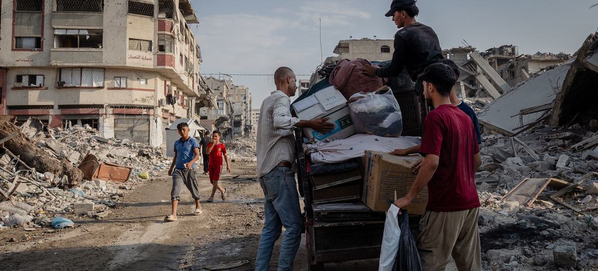 Men load possessions onto a cart in the al-Naser area of Gaza City. Men load possessions onto a cart in the al-Naser area of Gaza City.