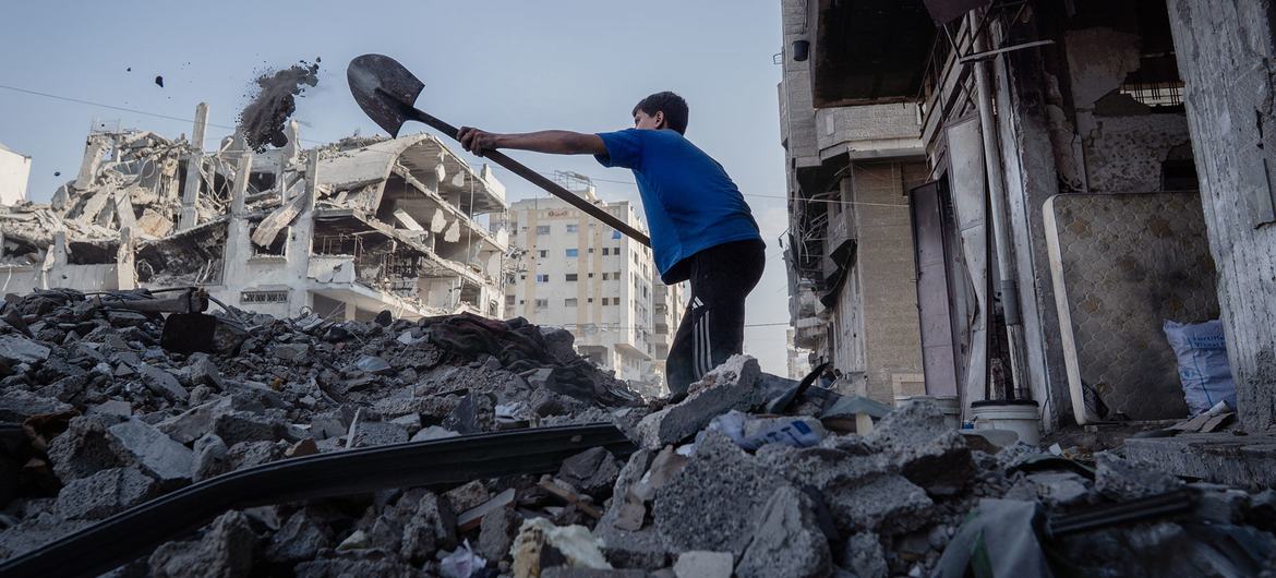 Un adolescente retira escombros de una vivienda en la ciudad de Gaza.