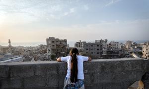 A girl looks over the destruction of Gaza City.