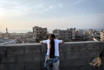 A girl looks over the destruction of Gaza City.