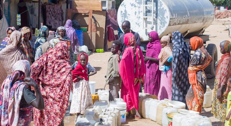 Niños y mujeres hacen cola para recoger agua limpia y potable de un camión cisterna en la ciudad de Zalingei, en Darfur central.