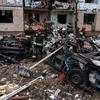 Спасатели работают у разрушенного в результате обстрелов здания в Киеве.