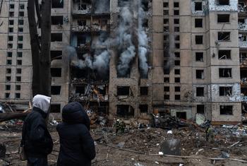 在基辅，人们看着一座建筑在导弹袭击后被烧毁。（资料图）