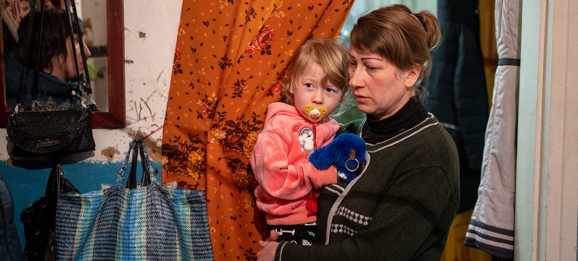 Uma mulher cuida de uma criança em uma casa na cidade de Izyum, na Ucrânia.