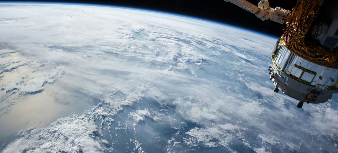 बाहरी अन्तरिक्ष से पृथ्वी और एक उपग्रह का नज़ारा.