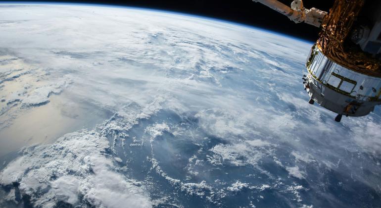 صورة للأرض وقمر صناعي من الفضاء الخارجي.