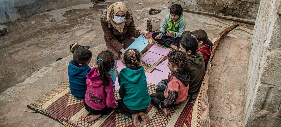 A health worker talks to displaced children about their hopes and worries in Atma camp, Syria.