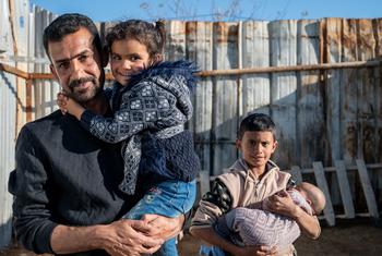 这位叙利亚难民是六个孩子的父亲，他抱着自己五岁的女儿。自2016年以来，他和家人一直住在约旦的阿兹拉克难民营。