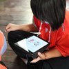 Estudante lê em um tablet em uma escola na Tailândia