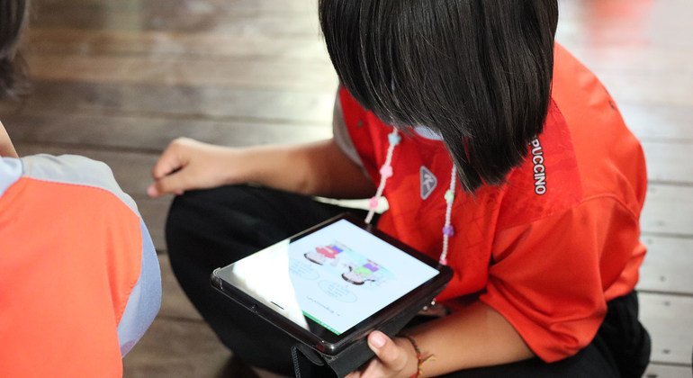 Estudante lê em um tablet em uma escola na Tailândia