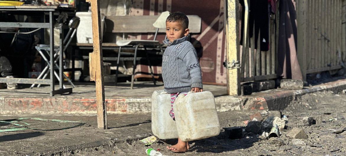 Un niño transporta bidones de agua en la Franja de Gaza.