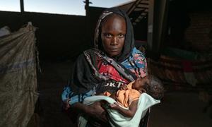 A woman holds her malnourished child at a displaced site in Gedaref, Sudan.