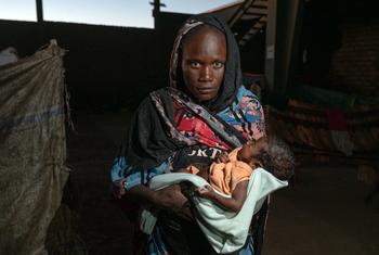 A woman holds her malnourished child at a displaced site in Gedaref, Sudan.