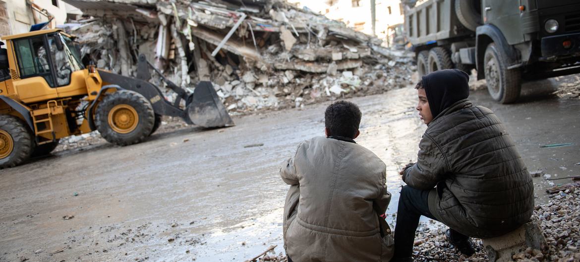 Two children look at damage caused by the February 2023 earthquake tin northwestern Syria.