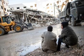 两个孩子注视着今年2月叙利亚西北部地震造成的破坏。