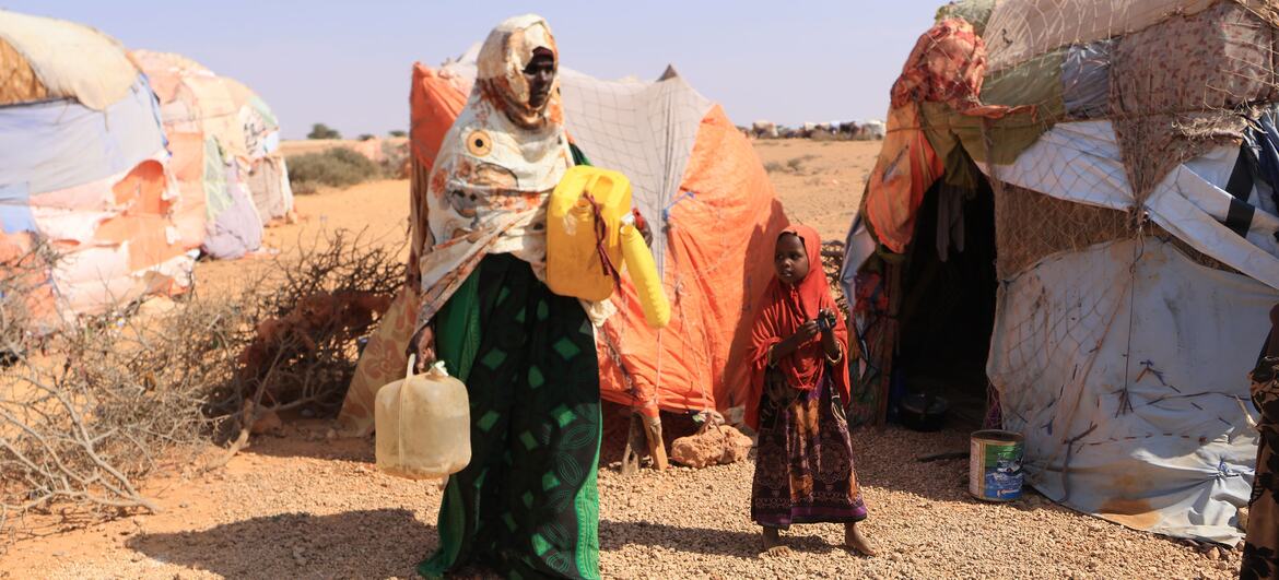 Una mujer y un niño se encuentran fuera de refugios temporales en una zona afectada por la sequía en Somalia.