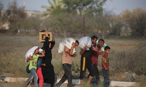 People carry sacks of food in Netzarim in central Gaza. 