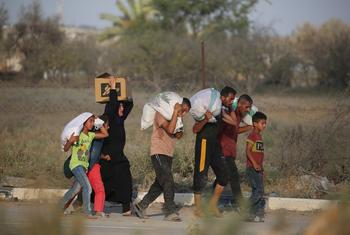 People carry sacks of food in Netzarim in central Gaza. 