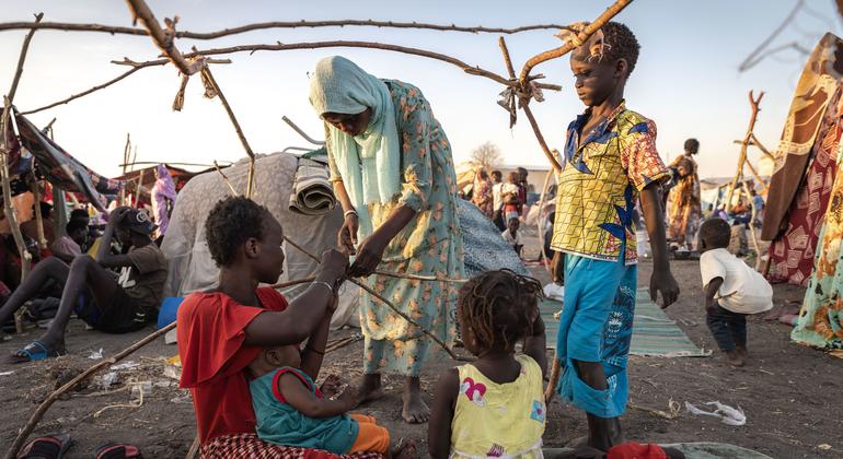 Refugees fleeing Sudan build a temporary shelter at the border with South Sudan. 
