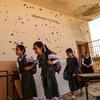 Schoolgirls in Anbar, Iraq, leave a classroom damaged by conflict.