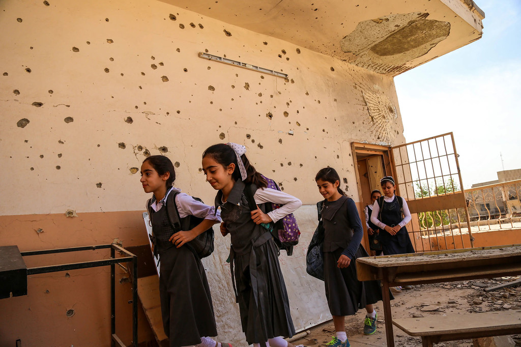 Des écolières d'Anbar, en Iraq, quittent une salle de classe endommagée par le conflit.