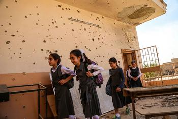 在伊拉克的安巴尔，女学生们离开了一间因冲突而受损的教室。