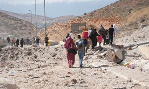 Families flee into Syria following airstrikes in Lebanon. 