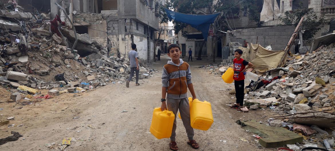 A boy collects water in a bombed neighborhood in Gaza. 